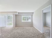 Thumbnail 5 of 14 - A room with a carpeted floor and a window with blinds.