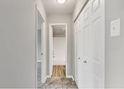 Thumbnail 10 of 14 - A hallway with a white door and a white wall.