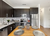 Thumbnail 30 of 57 - A modern kitchen with a wooden table and stainless steel appliances.
