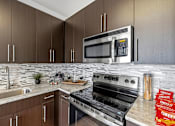 Thumbnail 29 of 57 - A modern kitchen with a stainless steel oven and microwave.
