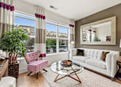 Thumbnail 28 of 57 - A living room with a white couch, a coffee table, and a large window with curtains.