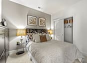 Thumbnail 23 of 57 - A bedroom with a large bed and a nightstand with a lamp.