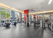 Thumbnail 19 of 57 - A gym with a variety of equipment including weights and cardio machines.