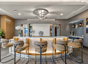 Thumbnail 20 of 57 - A modern bar area with a white counter and brown chairs.
