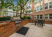 Thumbnail 52 of 57 - A patio with a grill and chairs.
