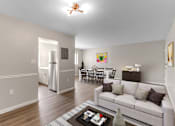 Thumbnail 1 of 12 - A living room with a white couch and a coffee table.