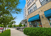 Thumbnail 47 of 57 - A sidewalk runs alongside a building with a blue awning.