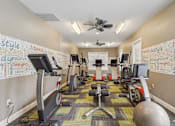 Thumbnail 7 of 14 - A gym with a variety of equipment including treadmills, exercise bikes, and weights.