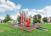 Thumbnail 3 of 14 - A playground with a red slide and a blue slide.