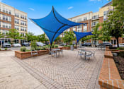 Thumbnail 40 of 57 - A blue shade structure is in the middle of a courtyard.
