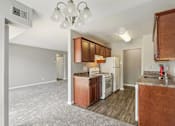 Thumbnail 13 of 14 - A kitchen with brown cabinets and white appliances.