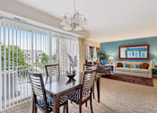 Thumbnail 4 of 14 - A dining room with a table and chairs and a view of the outside.