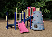 Thumbnail 29 of 33 - A playground with a pink slide and a grey rock climber.