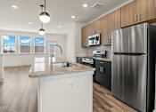 Thumbnail 49 of 57 - A modern kitchen with a stainless steel refrigerator and wooden cabinets.