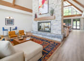 Thumbnail 17 of 43 - a living room with a stone fireplace and a rug