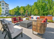 Thumbnail 30 of 43 - a patio with furniture and a fire pit