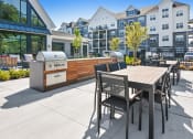 Thumbnail 31 of 43 - a patio with a barbecue grill and a table and chairs