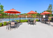 Thumbnail 35 of 43 - a patio with tables and umbrellas next to a pool
