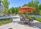 Thumbnail 36 of 43 - a patio with tables and umbrellas next to a swimming pool