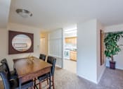 Thumbnail 6 of 18 - A dining room with a wooden table and chairs.