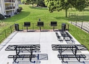 Thumbnail 12 of 18 - A black metal table and chairs are set up on a concrete patio.