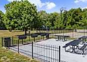 Thumbnail 13 of 18 - A black iron fence surrounds a picnic area.