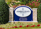 Thumbnail 11 of 11 - A sign for Admiral Place Apartments is displayed in front of some flowers.