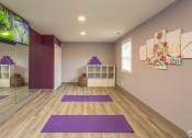 Thumbnail 27 of 29 - a yoga room with purple yoga mats and a tv