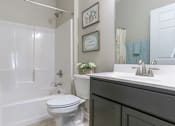 Thumbnail 4 of 17 - A white toilet is in a bathroom with a white door and a white sink.