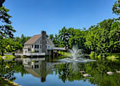 Thumbnail 10 of 26 - A house is reflected in the water of a pond.