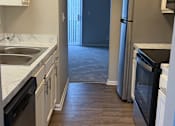 Thumbnail 6 of 59 - A kitchen with a black fridge and a black oven.