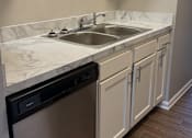 Thumbnail 7 of 59 - A kitchen with a stainless steel dishwasher and white cabinets.