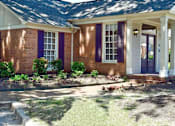 Thumbnail 2 of 15 - A house with purple shutters and a white door.