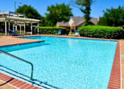 Thumbnail 13 of 15 - a large swimming pool with a pavilion and trees in the background