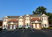 Thumbnail 6 of 23 - a house with two garages and a parking lot