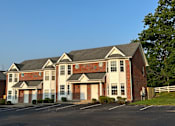 Thumbnail 5 of 23 - a large brick apartment building with a tree in front of it