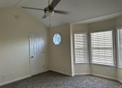 Thumbnail 22 of 23 - an empty bedroom with a ceiling fan and two windows