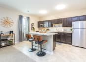 Thumbnail 4 of 22 - a kitchen with a bar and a stainless steel refrigerator