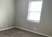 Thumbnail 40 of 42 - A room with a carpeted floor and a window with blinds.