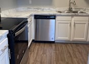 Thumbnail 37 of 42 - A kitchen with a black oven and a stainless steel dishwasher.