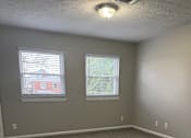 Thumbnail 57 of 59 - A room with grey carpet and two windows.