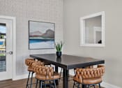 Thumbnail 6 of 16 - A dining table with four chairs and a potted plant.