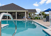 Thumbnail 17 of 23 - A swimming pool in front of a house with a slide.