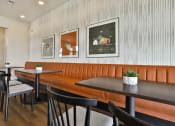 Thumbnail 24 of 28 - a dining room with orange booths and black tables and chairs at Aventura at Hawk Ridge, Lake St Louis, MO 63367