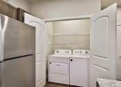 Thumbnail 7 of 28 - a kitchen with a washer and dryer and a refrigerator at Aventura at Hawk Ridge, Lake St Louis Missouri