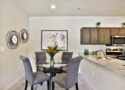 Thumbnail 9 of 28 - a dining room with a table and chairs and a kitchen  at Aventura at Hawk Ridge, Lake St Louis, 63367