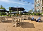 Thumbnail 26 of 28 - a patio with tables and chairs and umbrellas  at Aventura at Hawk Ridge, Lake St Louis, Missouri