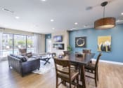 Thumbnail 18 of 31 - a living and dining area with a wooden table and chairs and a large window with a view at Aventura at Richmond, St. Peters, 63376