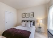 Thumbnail 15 of 31 - a bedroom with a bed and a nightstand  at Aventura at Richmond, St. Peters, MO