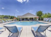 Thumbnail 17 of 37 - a swimming pool with blue chairs and a pavilion next to a resort style pool at Aventura at Towne Centre, Ellisville, Missouri